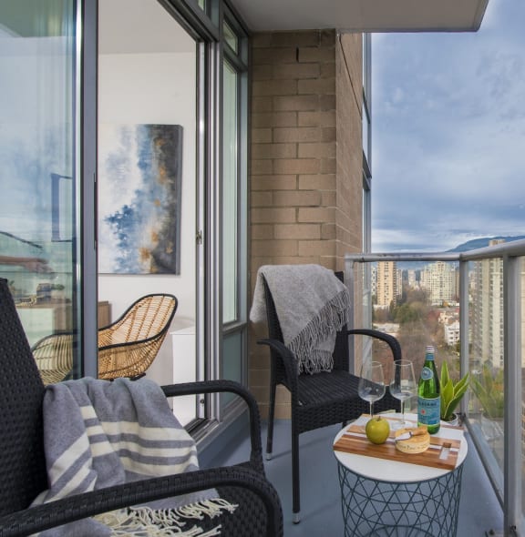 a balcony with a city view and a table and chairs on it