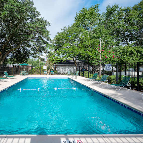 A large swimming pool surrounded by trees and chairs. at Woodlocke Apartments, South Carolina, 27461
