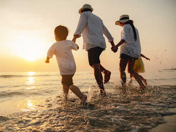 A man and a woman are walking on the beach.