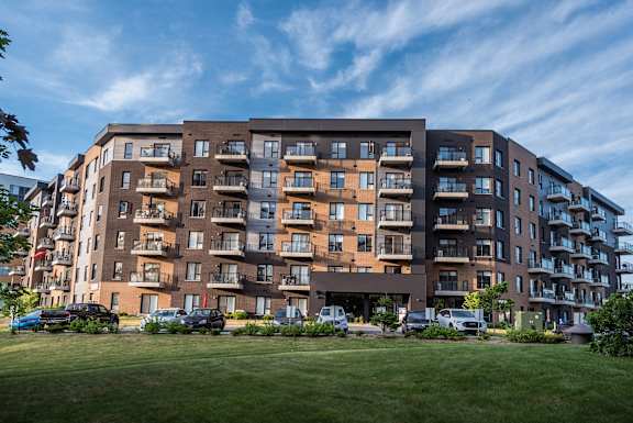 a large apartment building with cars parked in front of it