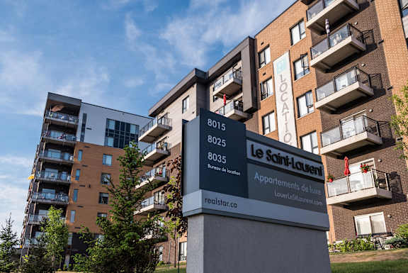 a large apartment building with a sign in front of it