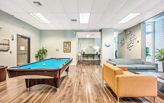 A room with a pool table and a couch.