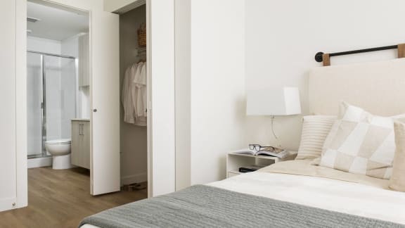 a bedroom with a bed and a bathroom with a shower