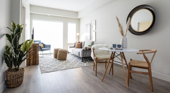 a living room with a round table and a mirror