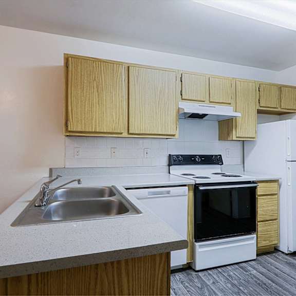 A kitchen with a white refrigerator, stove, and oven.