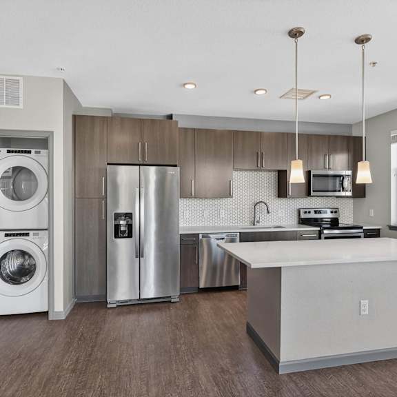 A modern kitchen with a white island and stainless steel appliances.