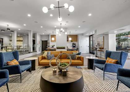A modern living room with blue chairs and a wooden coffee table.