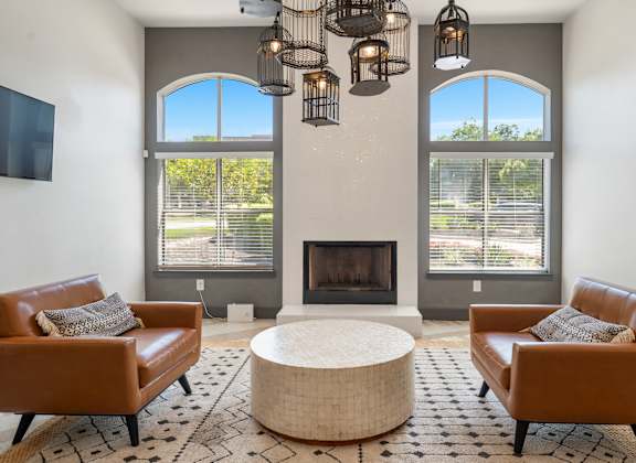 A living room with a fireplace and two chairs.