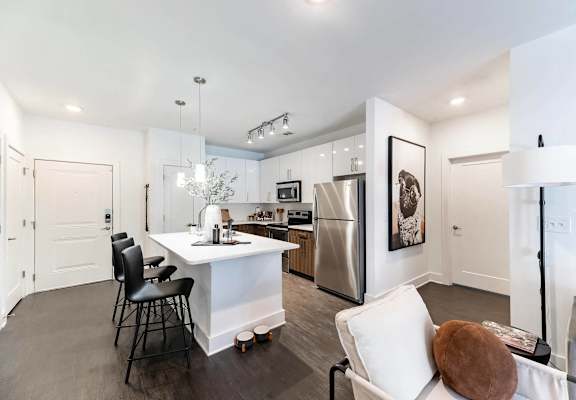 a kitchen with a white counter top and a stainless steel refrigerator