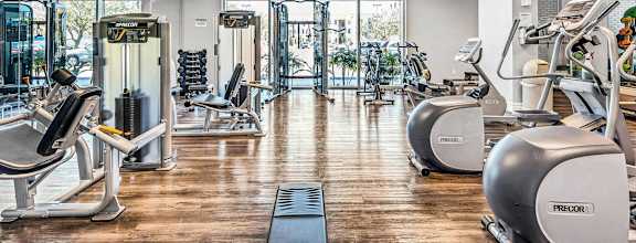 A gym with treadmills, elliptical machines, and other exercise equipment.