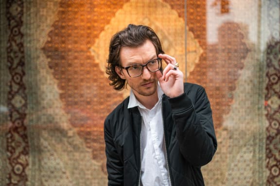 a man wearing glasses and a suit and tie talking on a cell phone