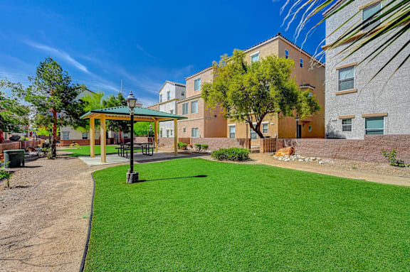 A sunny day at a park with a green lawn and a playground.