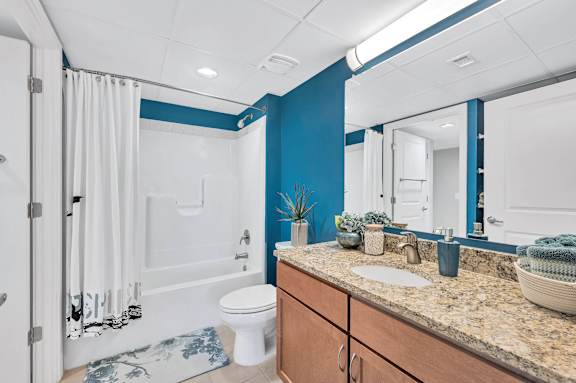 A bathroom with a blue wall and a white toilet.