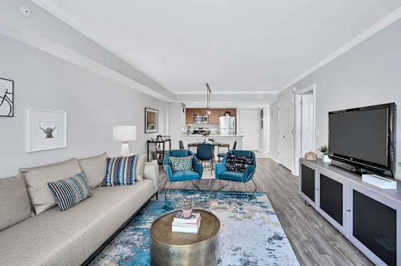 A living room with a sofa, chairs, and a television.