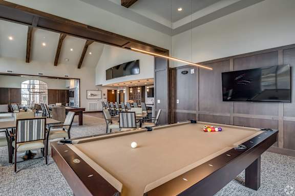 a clubhouse with a pool table and a tv
