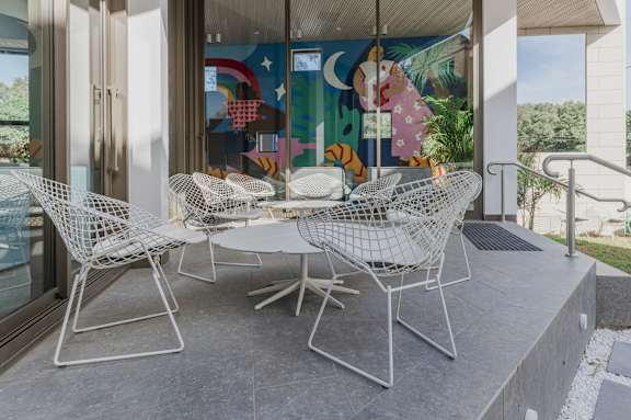 a dining area with a table and chairs and a painting on the wall