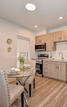 A modern kitchen with a dining table and chairs.