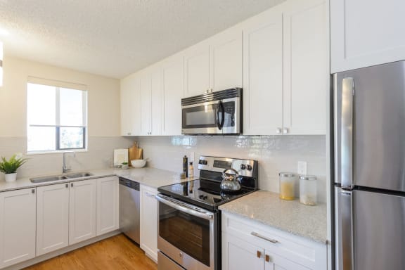 a kitchen with stainless steel appliances and white cabinets