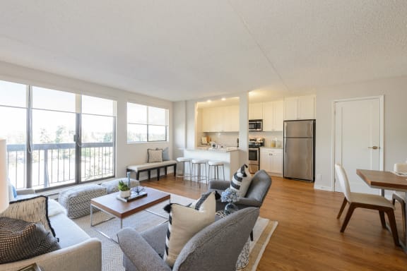 a living room with couches and chairs and a kitchen with a table