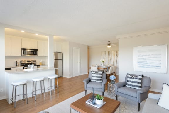 a living room and kitchen with a dining area and a bar