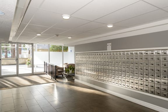 a lobby with a wall of mailboxes and a staircase