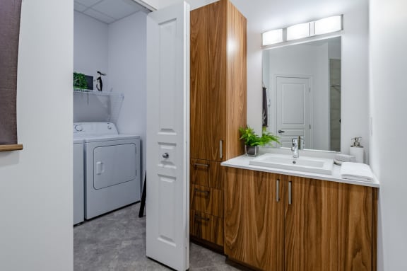 a bathroom with a washer and dryer and a sink and a laundry room