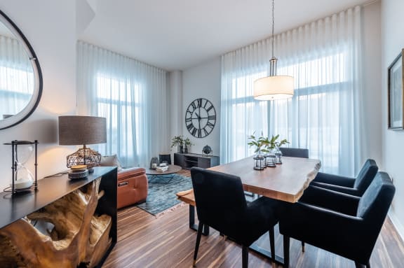a dining room with a table and chairs and a clock on the wall