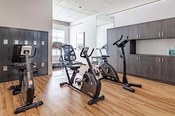 a gym with exercise equipment on the hard wood floor