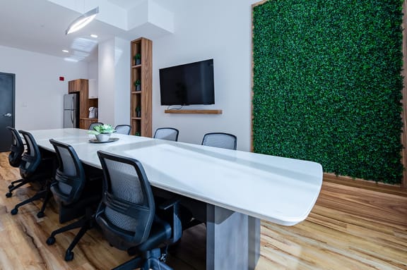 a conference room with a white table and chairs and a green wall
