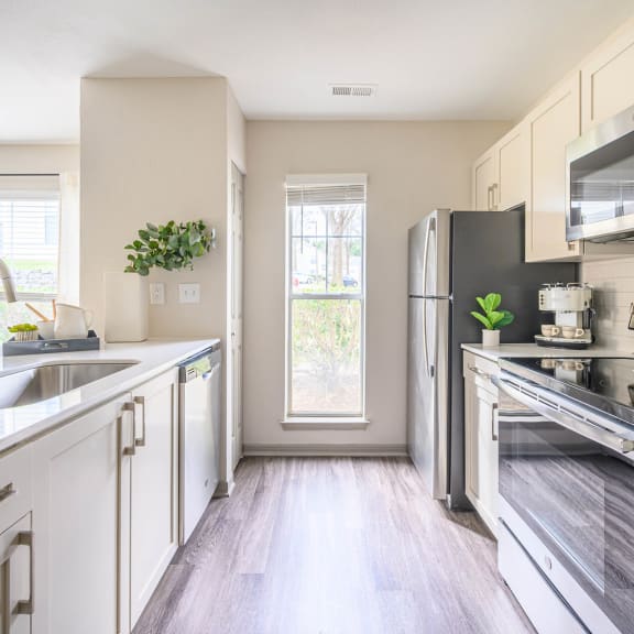 a modern kitchen with stainless steel appliances and white cabinets at Ashford Green, Charlotte, 28262