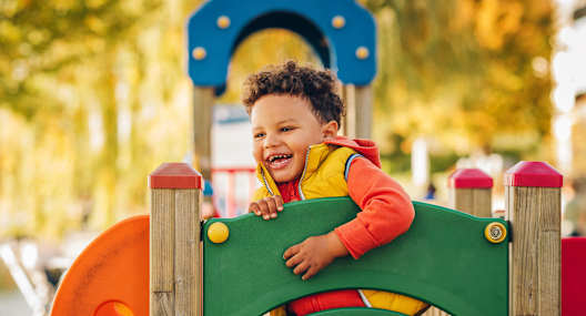 A child is playing on a playground slide.