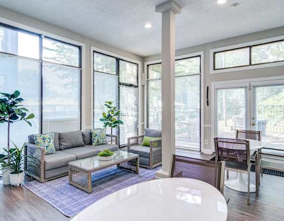 a living room with a couch and a table in front of windows at Glen Hollow, Decatur, Georgia