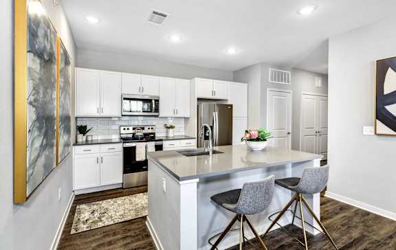 a kitchen with white cabinets and a counter top at Farmhaus Apartments, Alabama, 35757