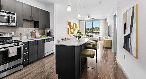 A modern kitchen with a large island and stainless steel appliances.