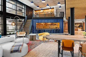 A modern interior with a staircase, chairs, and a table.