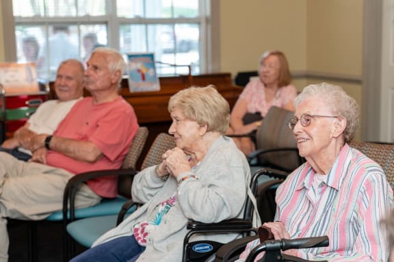 a group of elderly people sitting in wheelchairs in a room