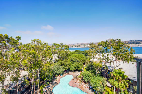 an aerial view of a swimming pool with trees and a body of water  at Mariners Village, California
