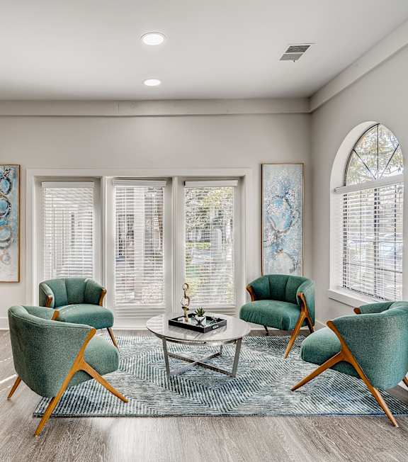 A living room with a wooden cabinet, a coffee table, and three chairs.