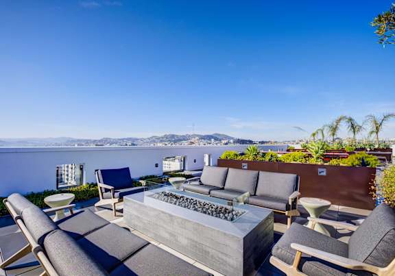 A patio with a table and chairs overlooking a body of water.