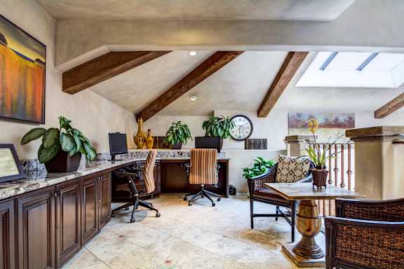 a home office with a desk and a table with chairs
