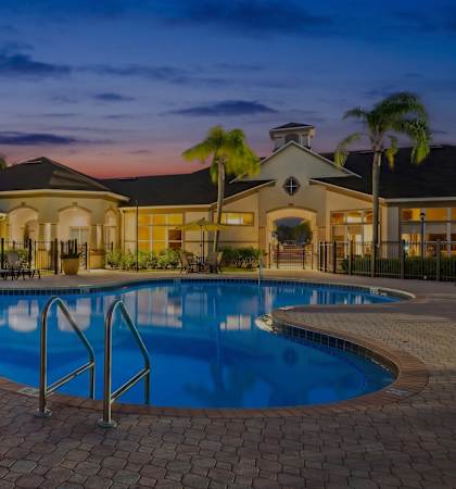 Resort-style swimming pool at dusk - Asprey at Lake Brandon Apartments
