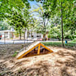 A playground with a blue slide and wooden structure.