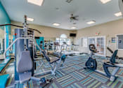 Thumbnail 2 of 8 - A gym with a variety of equipment including treadmills, weights, and exercise machines.
