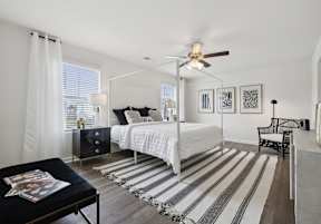 a bedroom with a bed and a ceiling fan