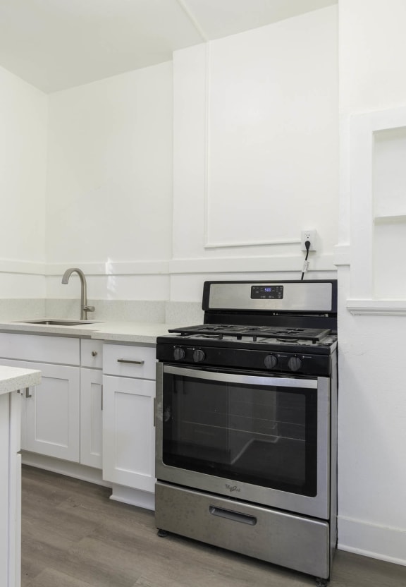 a white kitchen with stainless steel appliances and white cabinets at Clay & Tiffany, Portland, 97201
