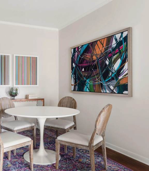 A dining room with a white table and chairs.
