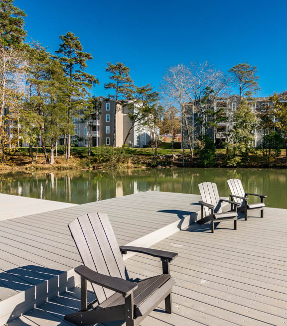 a dock with chairs on a lake with apartments in the background at Village at Westland Cove Apartments, Knoxville, TN, 37922