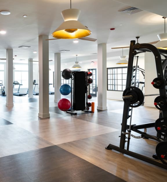 a gym with weights and other exercise equipment on the floor at The Quincy Apartments in Acworth, GA