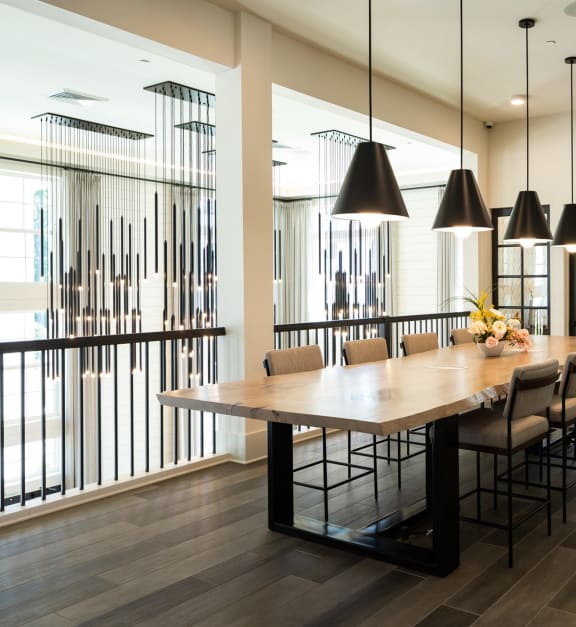 a dining room with a long wood table and chairs at The Quincy Apartments in Acworth, GA 30102