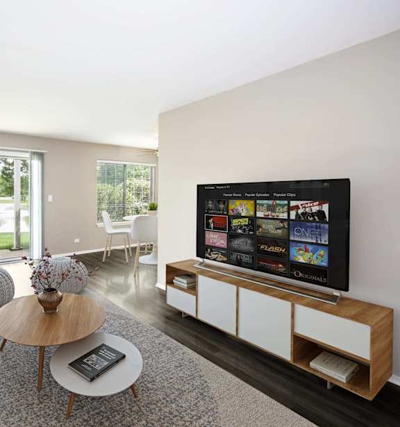 A modern living room with a grey couch, a wooden coffee table, and a flat screen TV.
